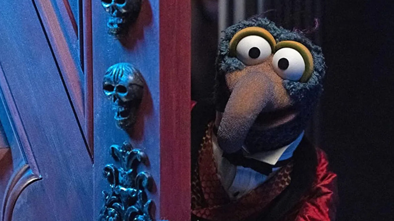 Gonzo the Great opens the door to the Haunted Mansion in Muppets Haunted Mansion