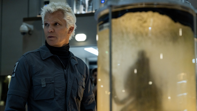 Kirsh stands in front of a tank containing an alien creature in Alien: Earth
