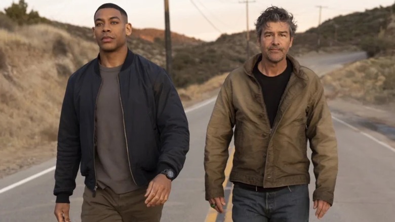 Aaron Pierre and Kyle Chandler walking down a highway together