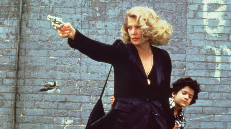 Gena Rowlands wields a pistol as Gloria Swenson to protect John Adames as Phil Dawn in Gloria (1980)