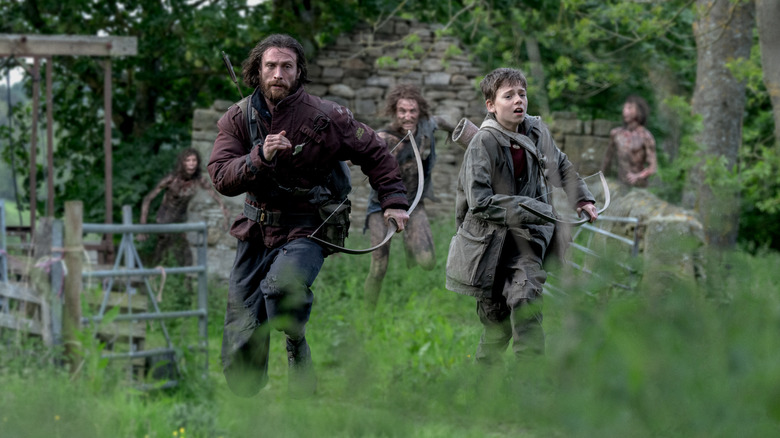 Aaron Taylor Johnson as Jamie and Alfie Williams as his son Spike fleeing from zombies in 28 Years Later