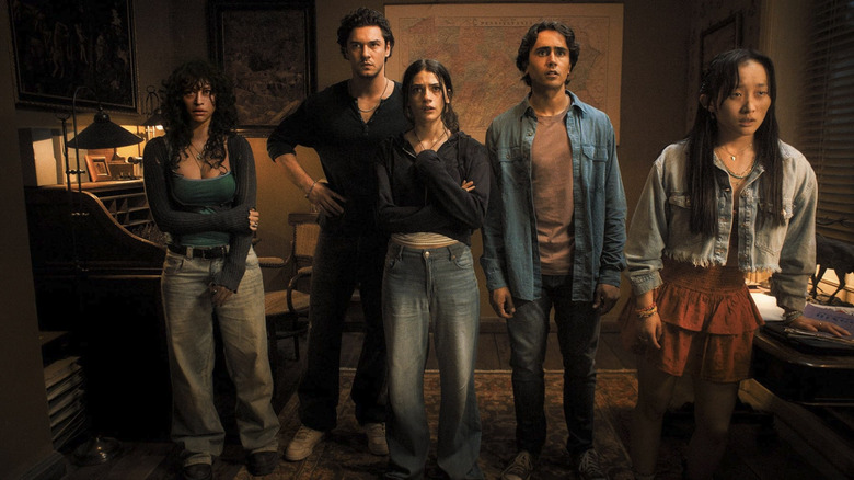 The cast of Until Dawn stands looking at a board of missing posters in Until Dawn