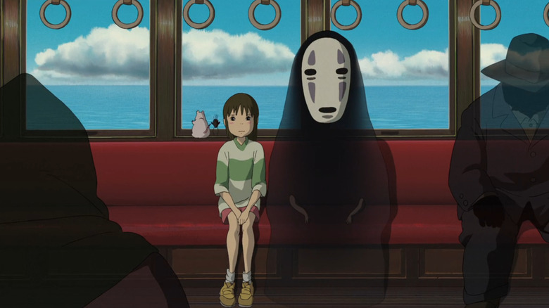 Spirited Away, Chihiro and No-Face sitting on a train, surrounded by spirits.