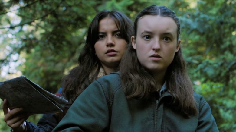 Ellie navigates on horseback while Dina holds the map as the pair travel through the woods in 