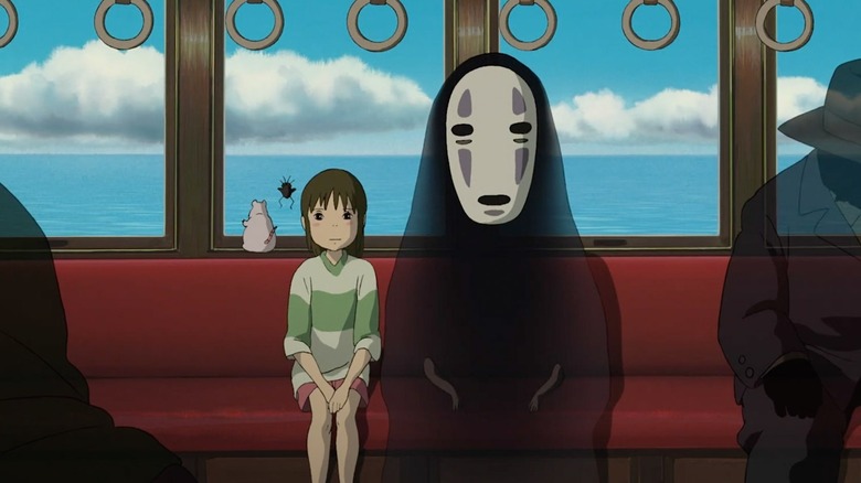 Chihiro and No-face on the train in Spirited Away