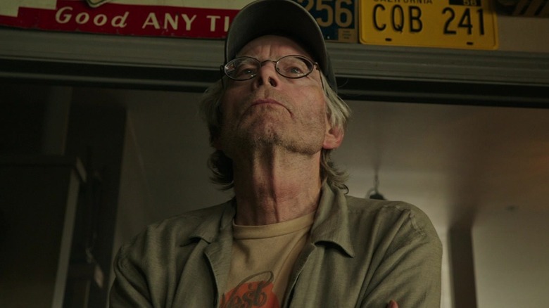 A pawn shop owner boasting a serious expression in 