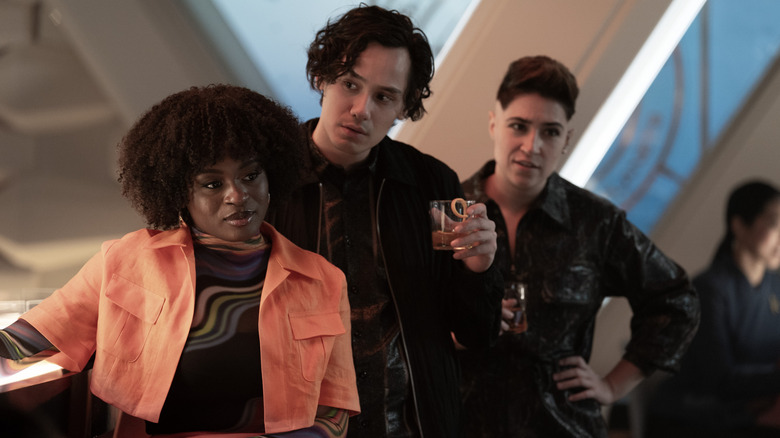 Celia Rose Gooding as Uhura, Mynor Luken as Beto, and Melissa Navia as Erica Ortegas standing by a bar and holding drinks in Star Trek: Strange New Worlds