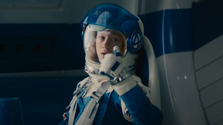 Joseph Quinn as Johnny Storm/Human Torch wearing a space suit and giving a thumbs up in The Fantastic Four: First Steps