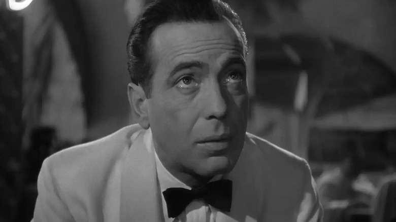 Rick outside of his cafe wearing a white suit in Casablanca