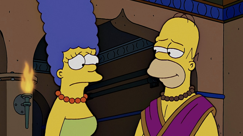 Marge and Homer Simpson stand side by side in a temple in The Simpsons