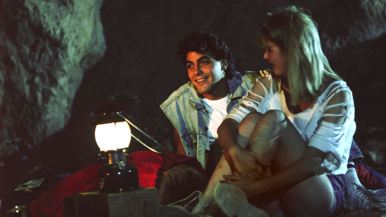 Ron (Clooney) and Tina (Dern) hanging out in a cave together in Grizzly 2: Revenge
