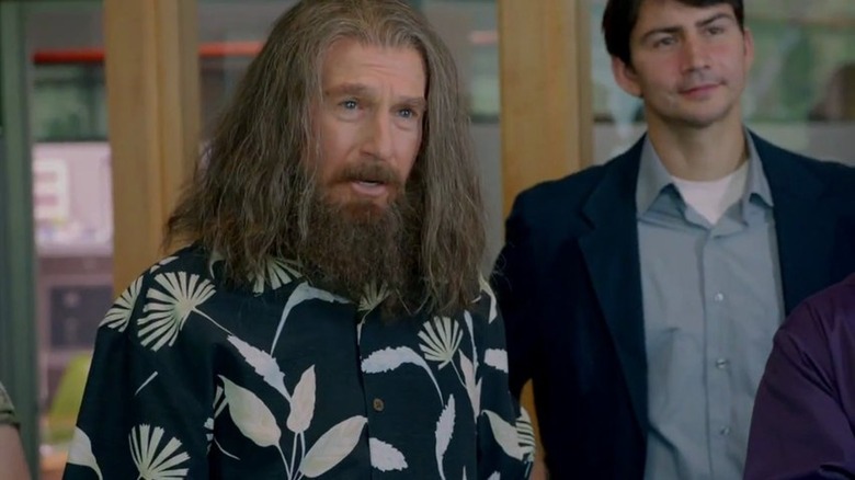 Nathan Flomm, wearing a Hawaiian shirt with long flowing hair and a bushy beard, looks dumbfounded with his mouth open in 
