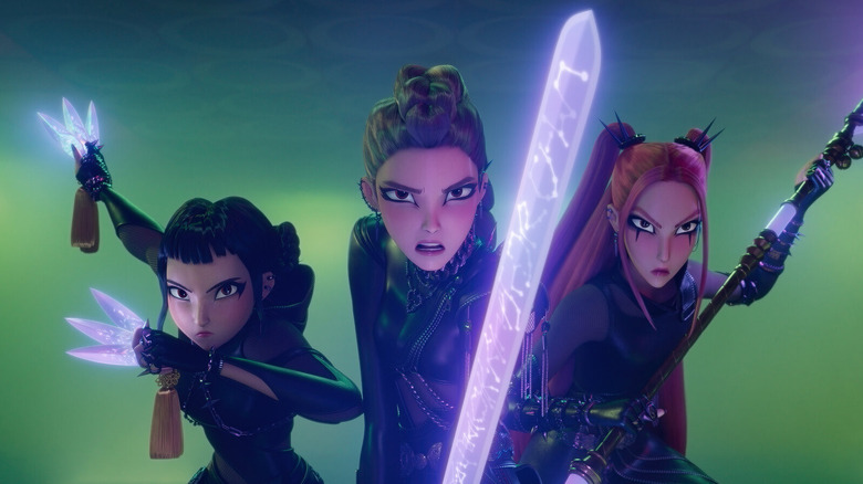 HUNTR/X stars Rumi, Zoey and Mira, dressed in black leather demon hunting gear and armed with their glowing purple energy weapons, prepare to take down demons in 
