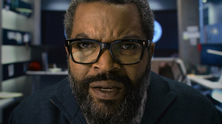 Ice Cube's Will Radford is seen in closeup siting in his office in War of the Worlds