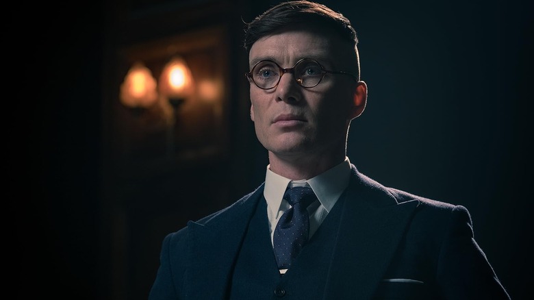 Tommy Shelby (Cillian Murphy) wearing glasses and looking serious in Peaky Blinders