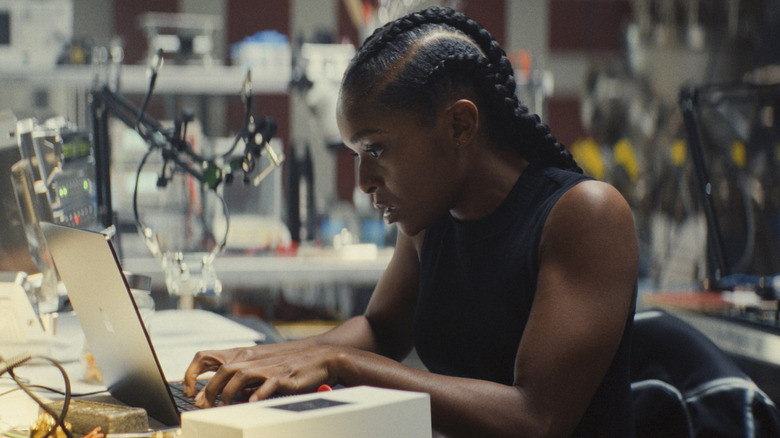 Riri Williams in a lab, working on her laptop