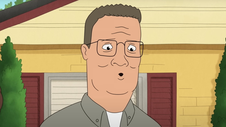 Hank looking at his cell phone with Peggy behind him on King of the Hill