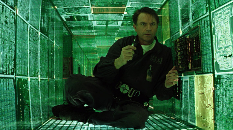 Sam Neill as Dr. Weir surrounded by green glowing panels in Event Horizon
