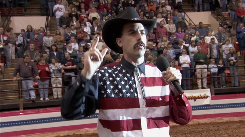 Sacha Baron Cohen as Borat attending a rodeo in an American flag button down shirt