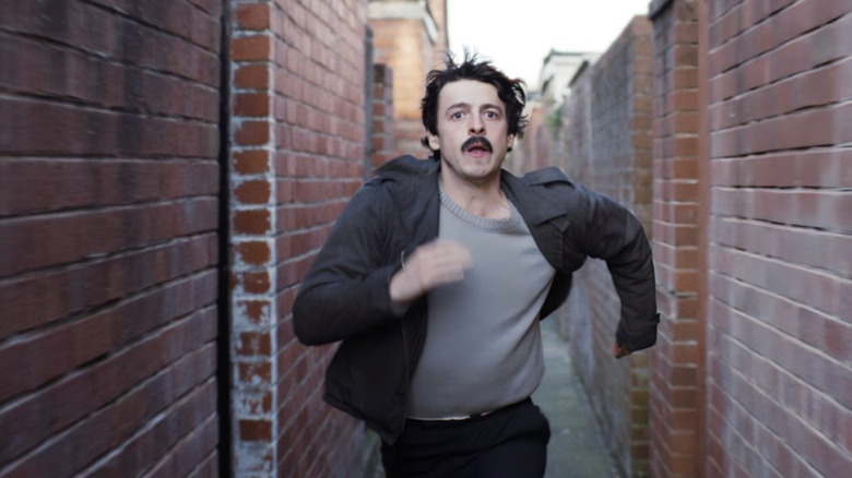 Anthony Boyle as Brendan Hughes running through an alley in Say Nothing