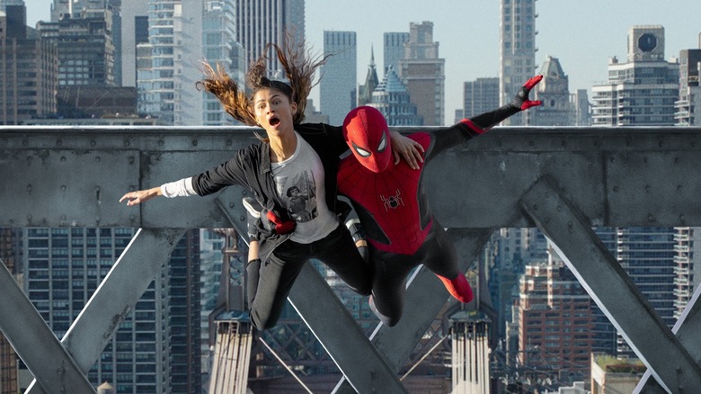 Zendaya as MJ flying through the air with Tom Holland suited up as Spider-Man in Spider-Man: No Way Home