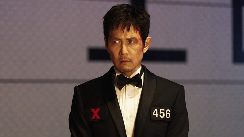 Gi-hun wears a tuxedo and sits at a dinner table in Squid Game season 3
