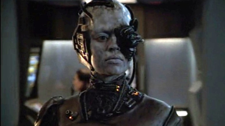 Jeri Ryan as Seven of Nine stands in her Borg form and looks ahead in Star Trek: Voyager