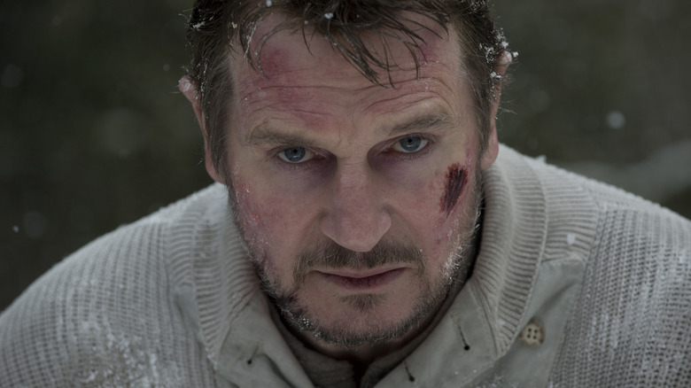 Liam Neeson as John Ottway facing down a wolf in The Grey