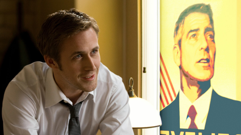 Ryan Gosling as Stephen Meyers, sitting in front of a Mike Morris poster in The Ides of March