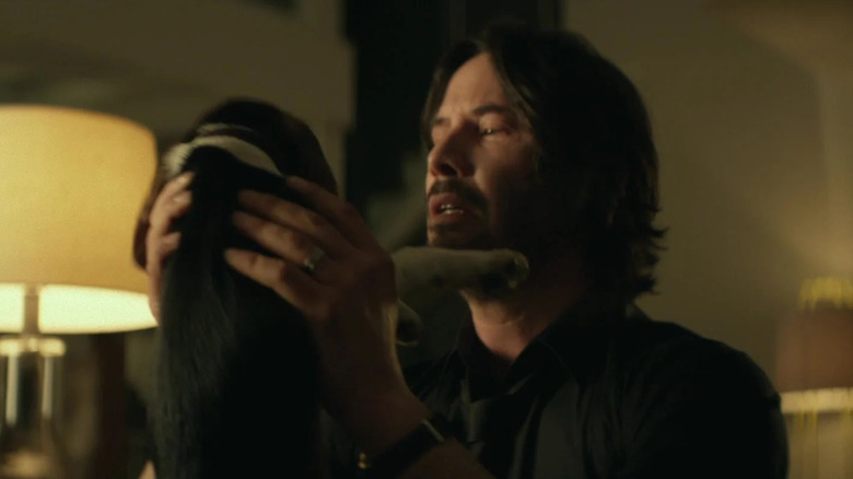 Keanu Reeves' John Wick holds his puppy in John Wick