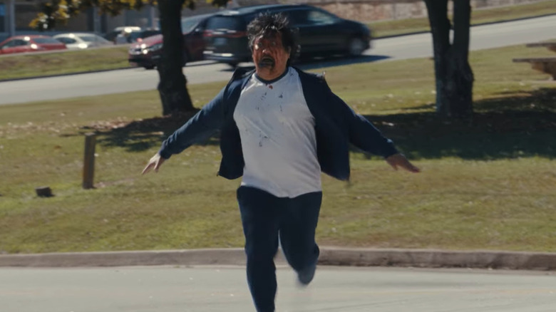 Benedict Wong as Andrew running towards Justine with a bloody face in Weapons