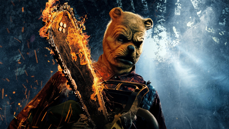 Winnie the Pooh holding a flaming chainsaw on the poster for Winnie the Pooh: Blood and Honey 2
